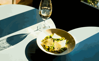 Le Rebelle in Perth, WA  restaurant dish and glass of white wine in bright sunlight