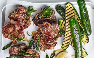 An aerial view of grilled lamb chops and grilled zucchini with lemon and rosemary.