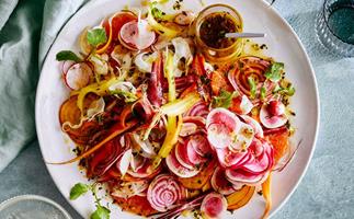 A colourful salad with finely shaved baby vegetables, such as beetroot, carrot, and radish.