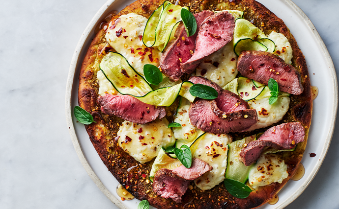 An aerial view of a lamb, zucchini and haloumi flatbreads with chilli honey